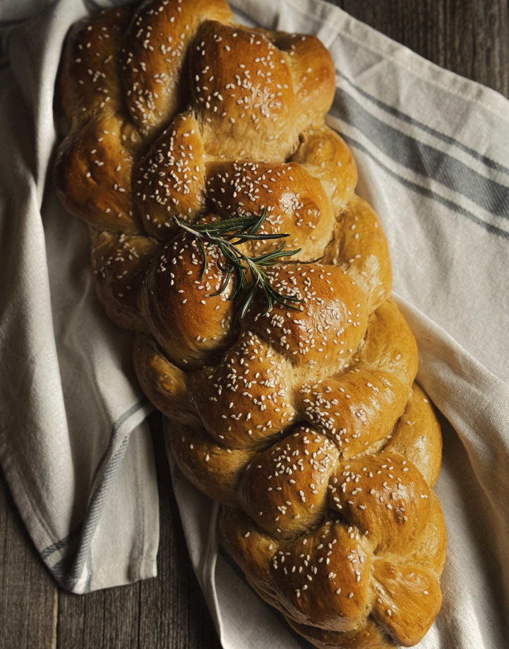 Braided challah loaf topped with sesame seeds, a recipe from Haven Table