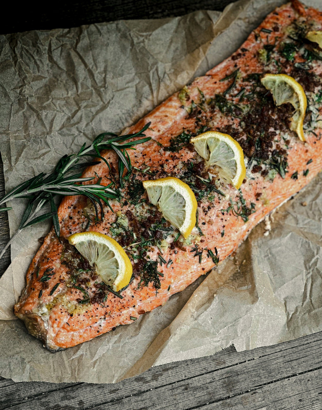 Baked Alaskan sockeye salmon with lemon slices, garlic and herbs