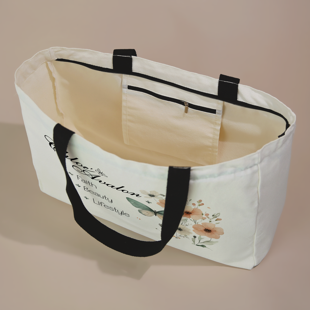 Inside of the Chloé Avalon tote bag showing the zippered inside pocket, with the butterfly floral design on the front and black handles