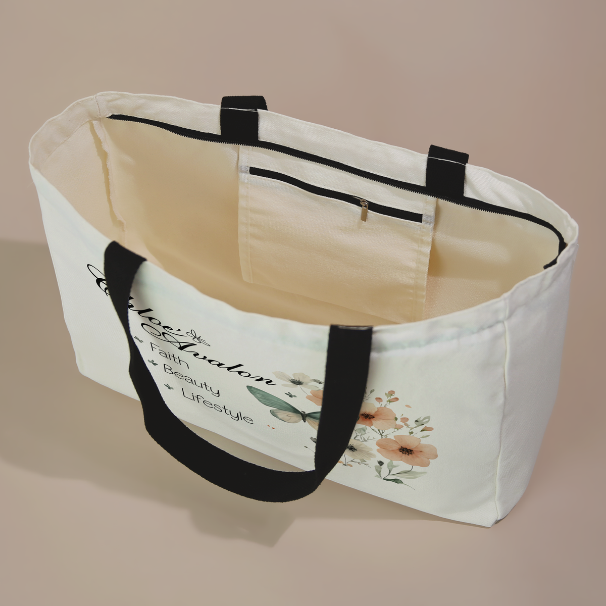 Inside of the Chloé Avalon tote bag showing the zippered inside pocket, with the butterfly floral design on the front and black handles